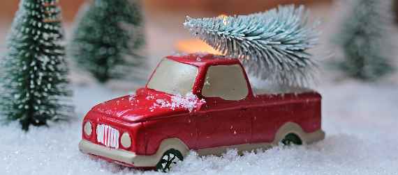Ein rotes Spielzeugauto mit Christbaum
