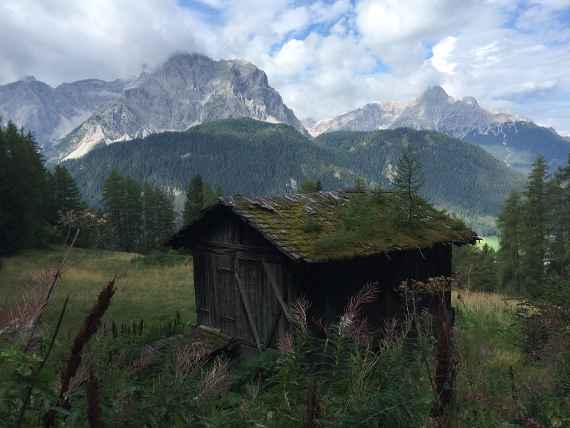Eine alte Hütte mit den Dolomiten im Hintergrund