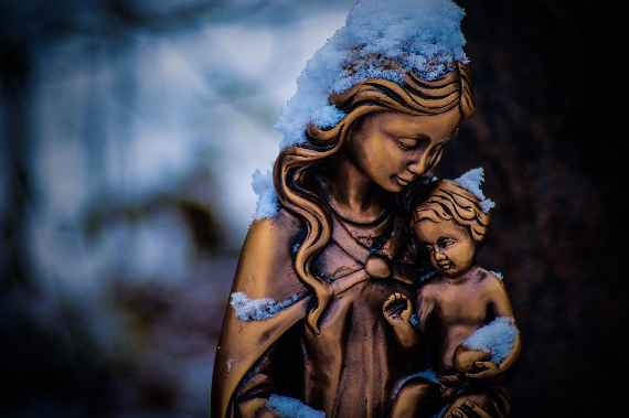 Bronzestatuette der Mutter Maria mit Kind schneebedeckt