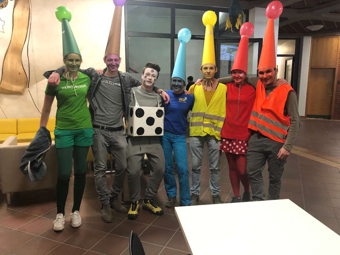 Sieben Schülerinnen und Schüler als Spielfiguren und Würfel verkleidet