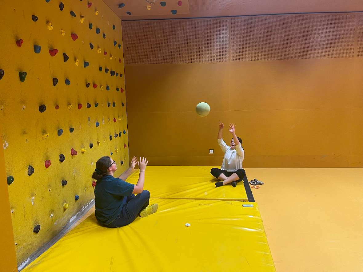 Zwei Mädchen spieln Ball im Boulderraum