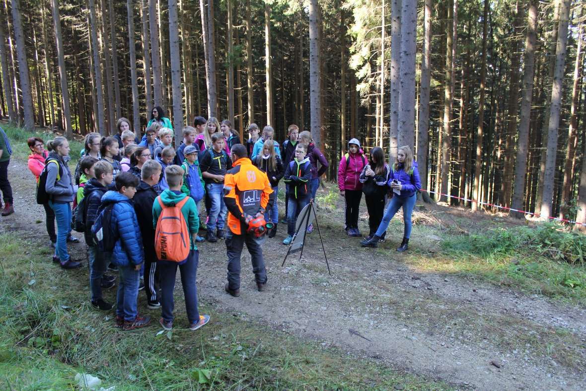Forstarbeiter mit Schülerinnen und Schüler