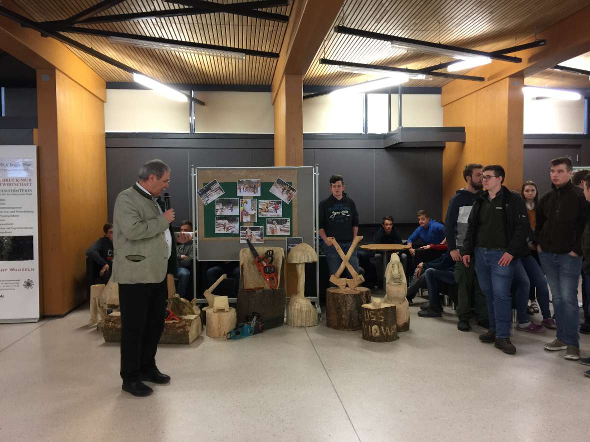 Der Direktor vor dem Stand der Holzschnitzer