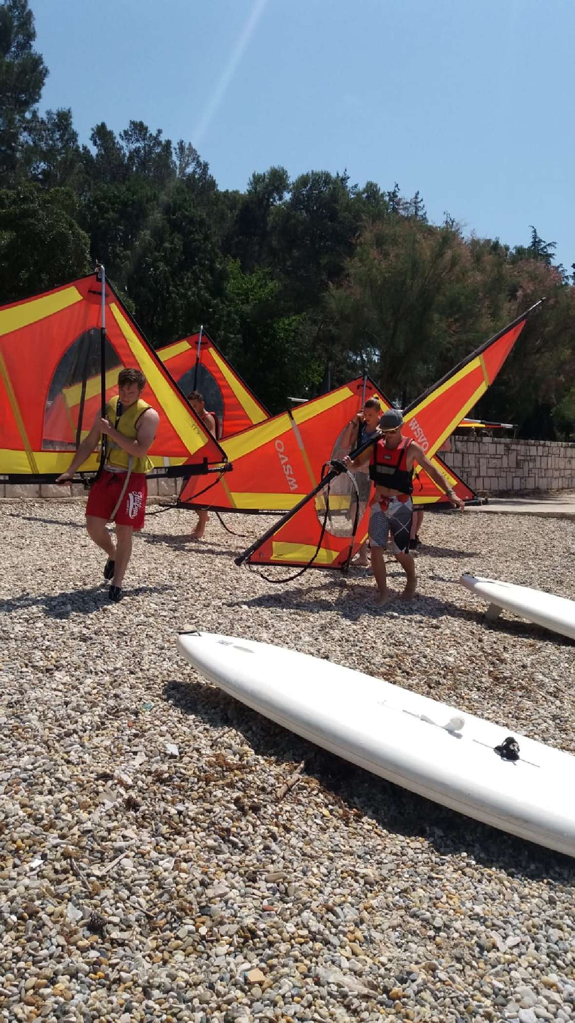 Surfsegel werden über den Strand getragen