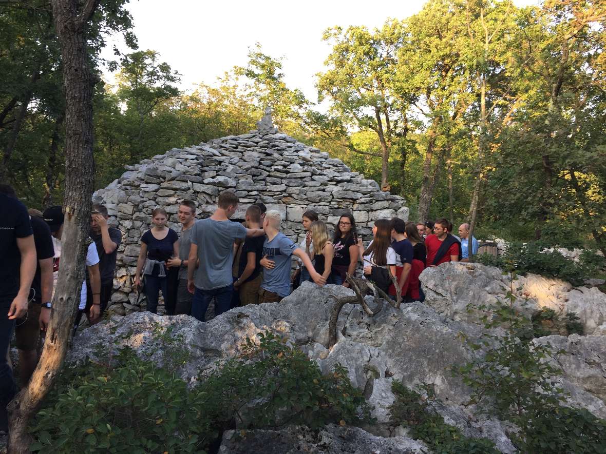 Gruppe vor einem geschichteten Steinmonument