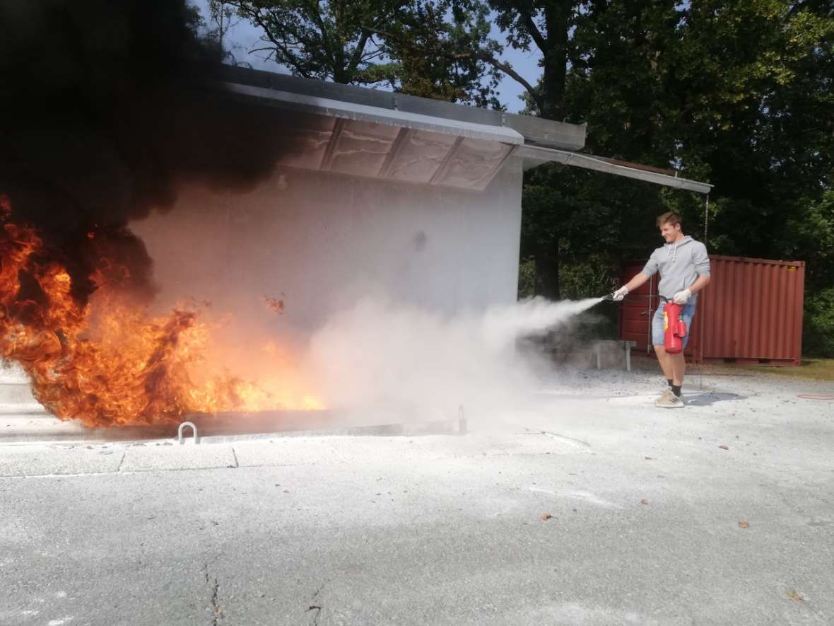 Schüler löscht einen Brand mit Handfeuerlöscher