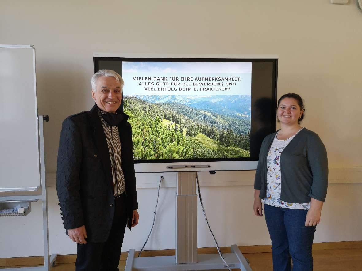 Die Vartragenden im Mehrzweckraum vor Bildschirm