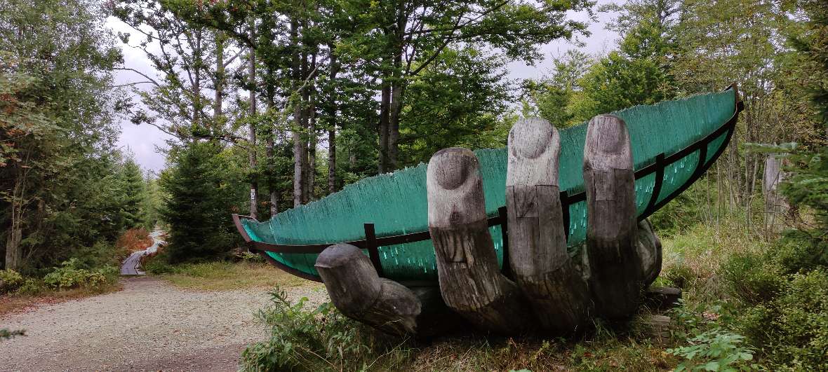 Kunstobjekt ist eine Riesenhand aus Holz die ein großes Blatt hält