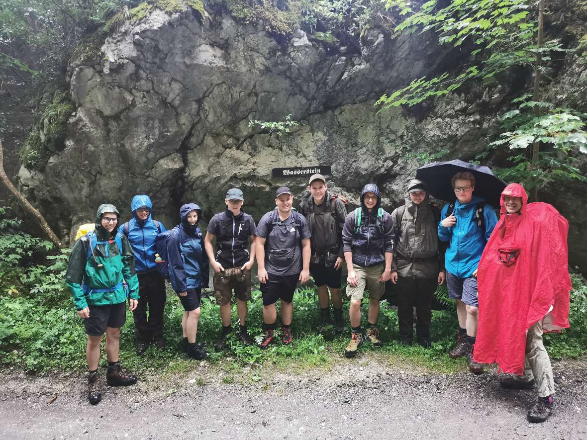 Gruppenbild vor einer nassen Felswand bei Regenwetter