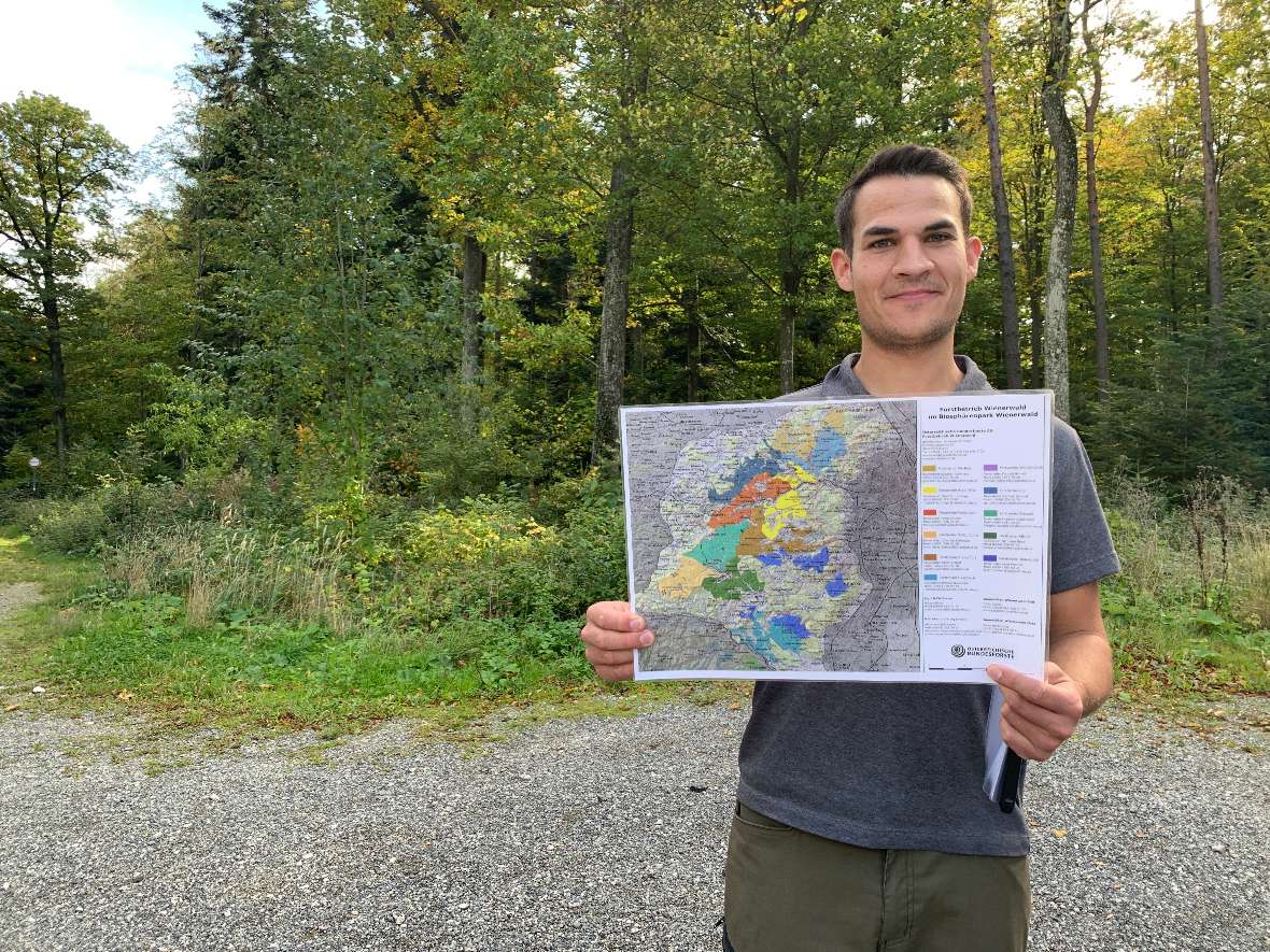 Eine Karte des Wienerwalds gehalten von einem Absolventen der Schule