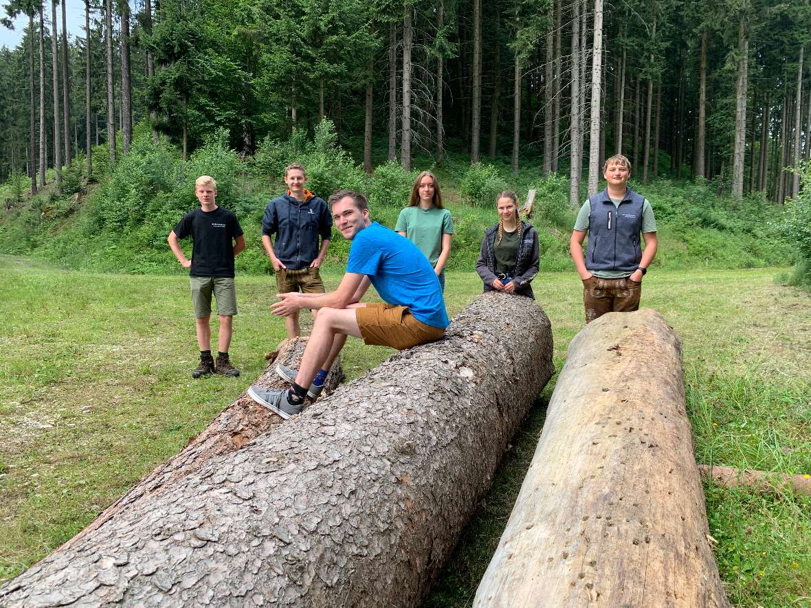 Gruppe wartet auf Holz sitzend