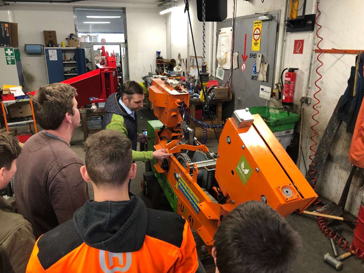 Schüler betrachten den Laufwagen eines Seilkrans indoor