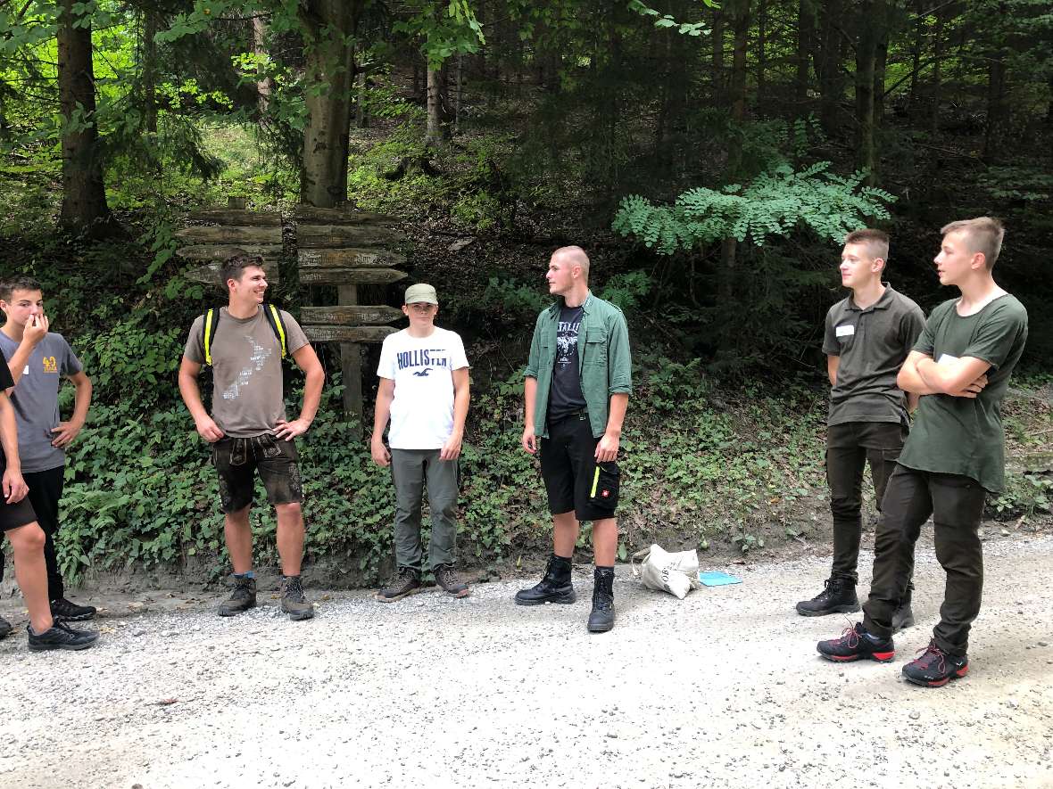 Schülergruppe steht auf einem Forstweg