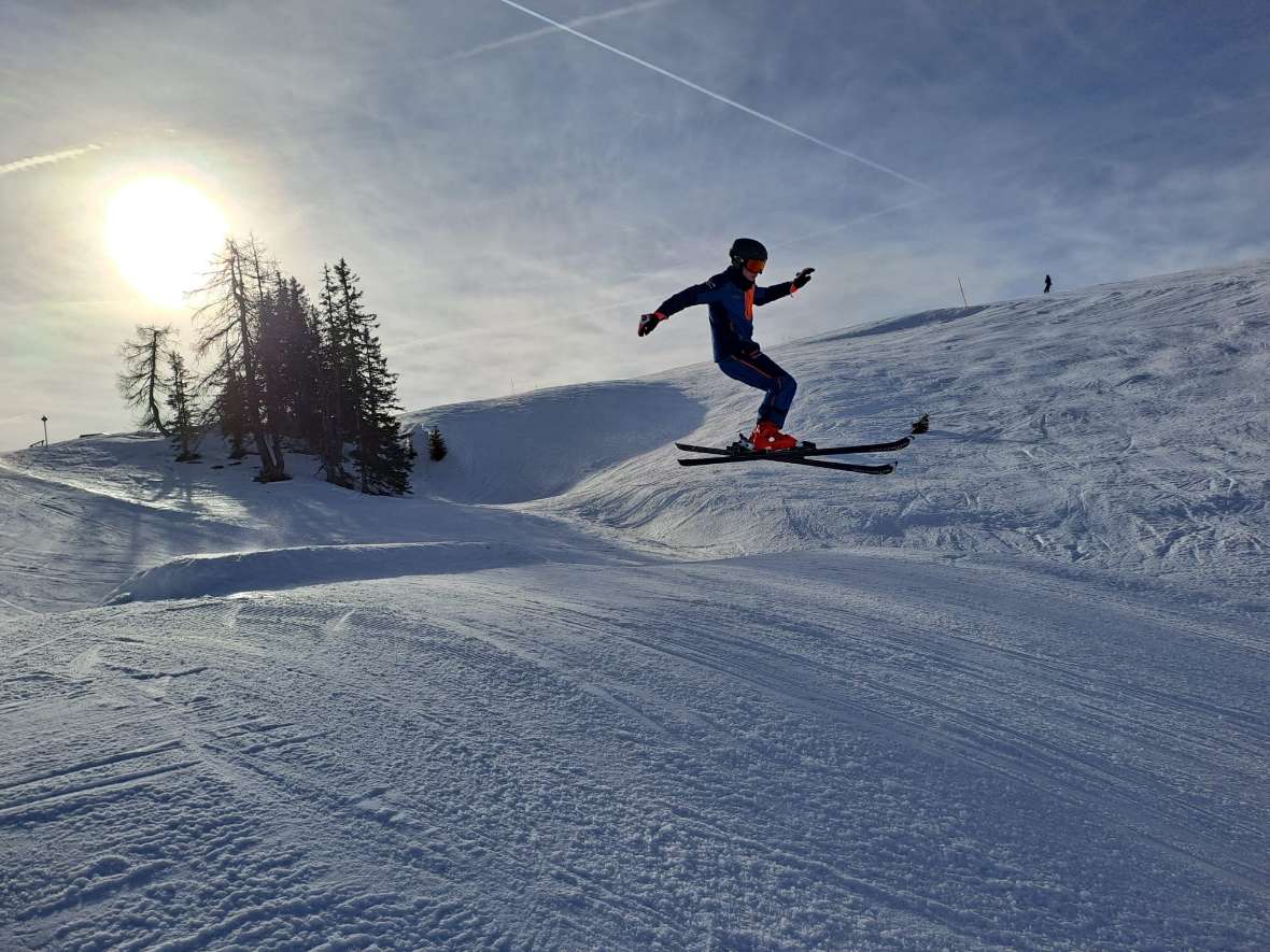 Schüler springt über Piste