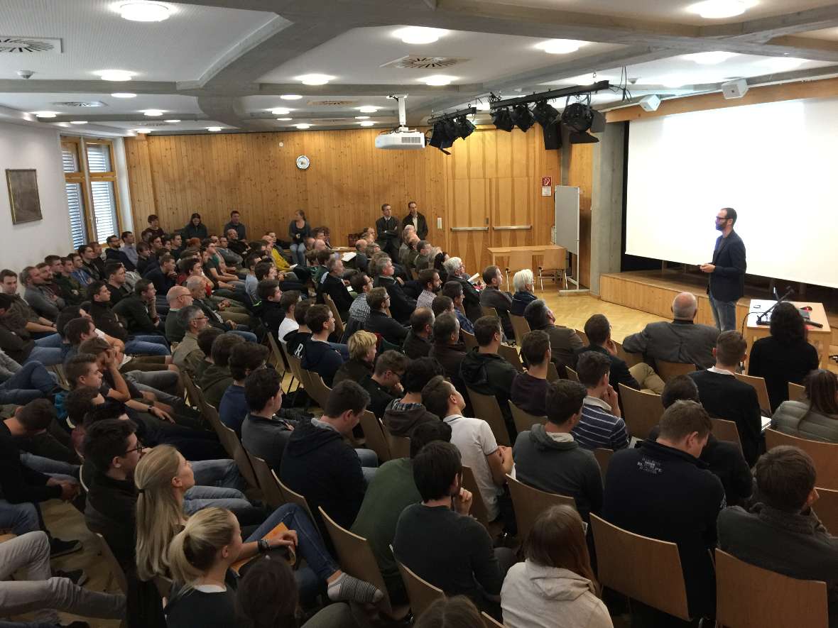 Der Festsaal ist voll und lauscht dem Vortrag