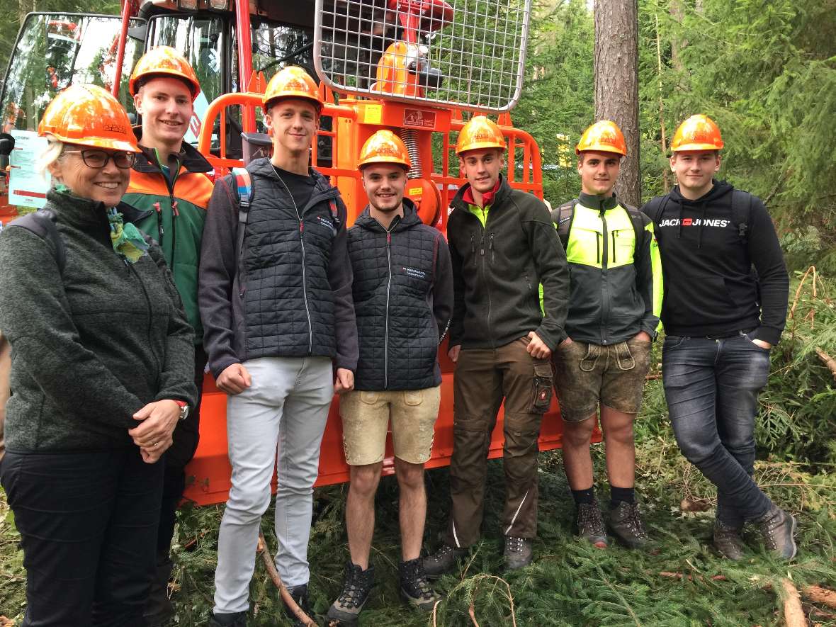 Schülergruppe mit Begleitlehrerin vor einem Traktor