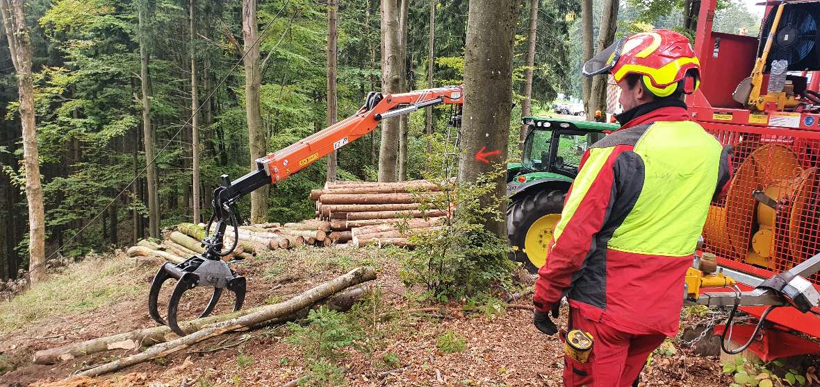 Greifarm des Traktors mit Holz