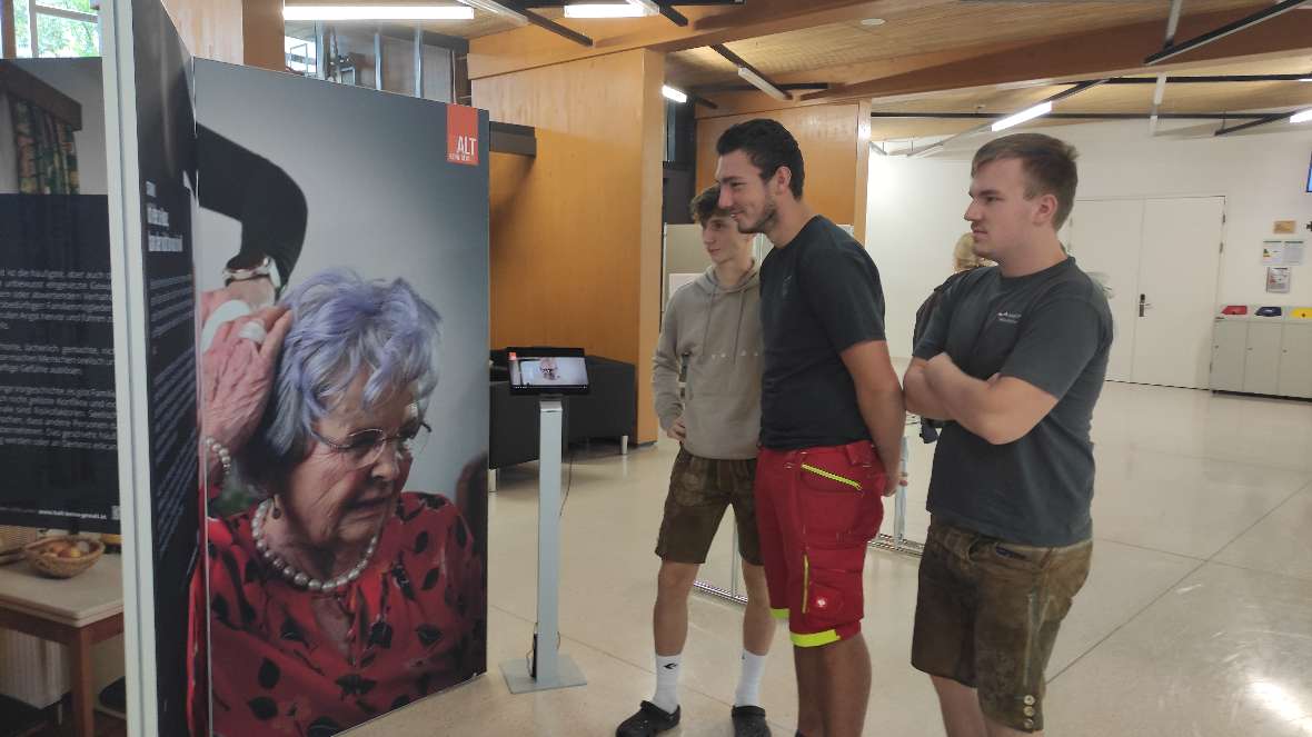 Schüler betrachten eine Ausstellungsplakat