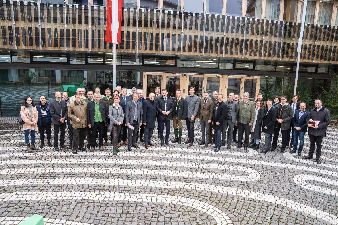 Gruppenbild vor dem Eingang. Alle versammelt um den Minister.